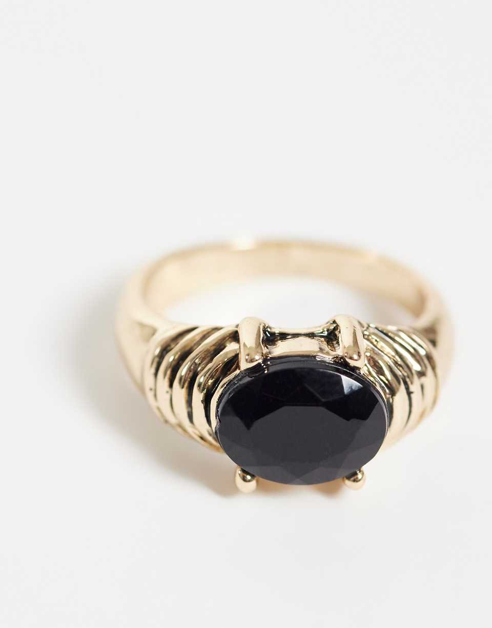 Gold tone ring with black set stone