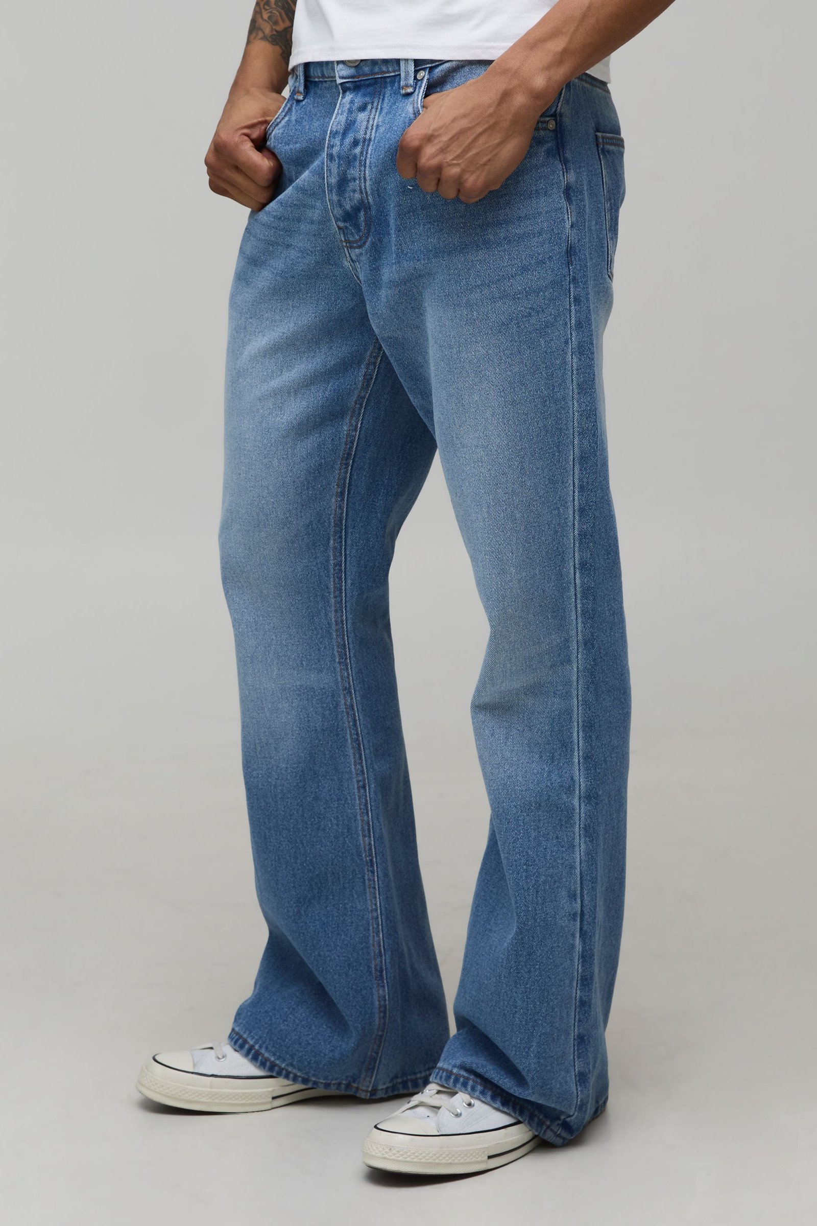 Jeans à poche brodée, coupe rigide et jambe évasée