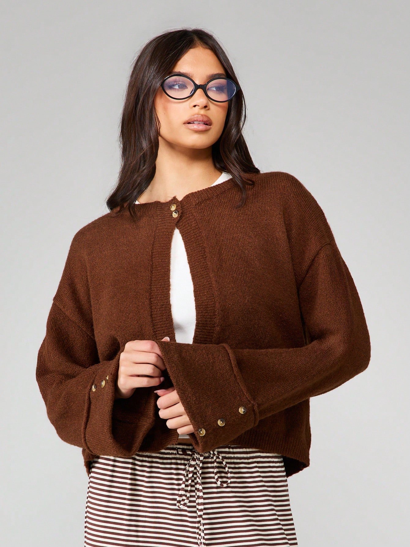 Cardigan qsir b zrar w poignets wasi3in
